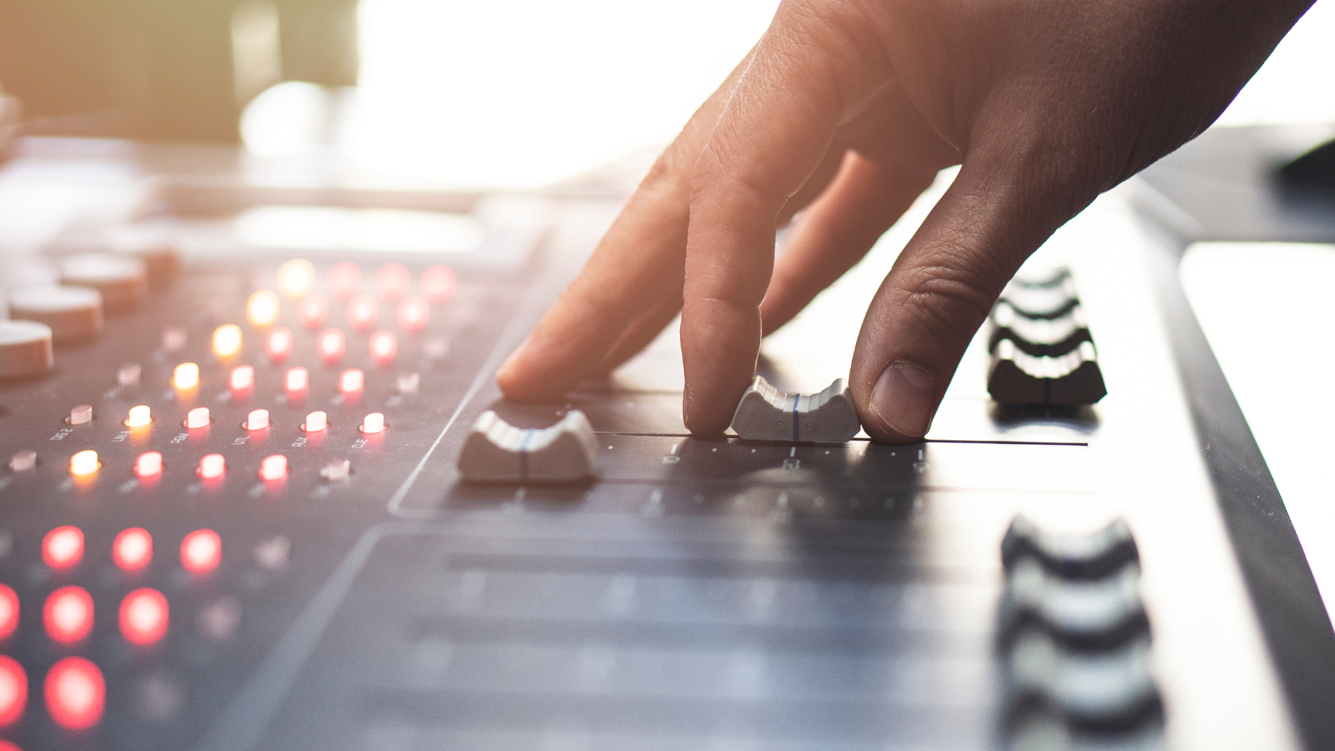 Main sur une console de mixage